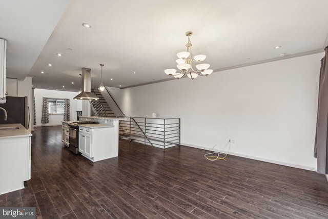 kitchen with pendant lighting, stainless steel gas range oven, white cabinetry, and dark wood-type flooring