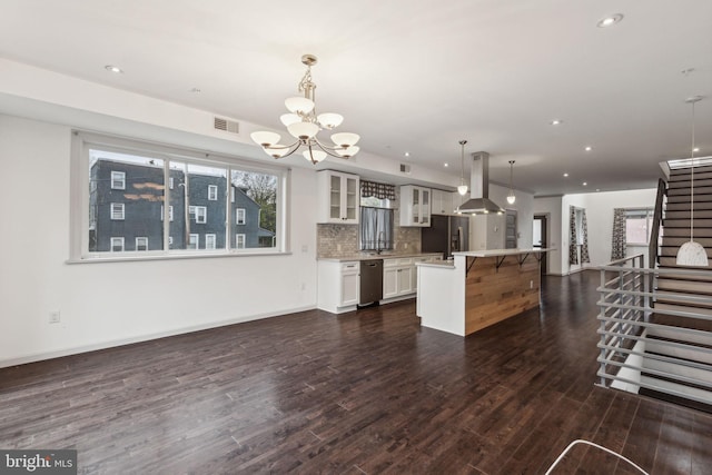 kitchen with island exhaust hood, stainless steel appliances, dark wood-type flooring, decorative light fixtures, and a kitchen island