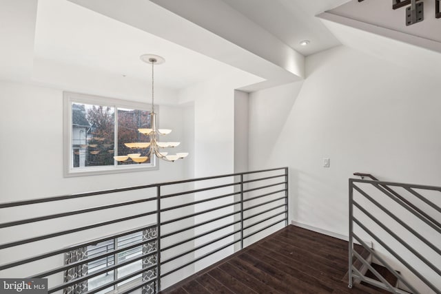 hall with a notable chandelier and dark hardwood / wood-style flooring