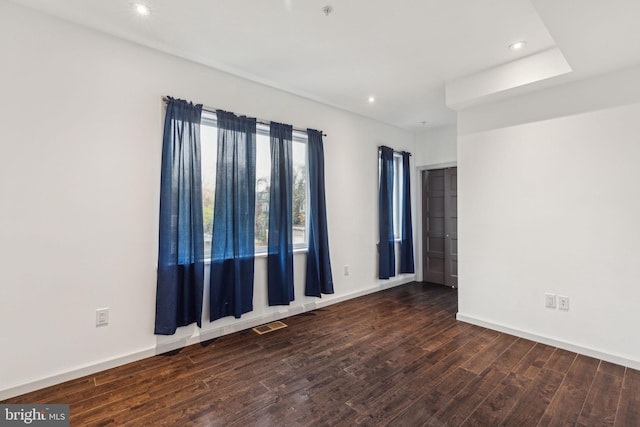 unfurnished room with dark wood-type flooring