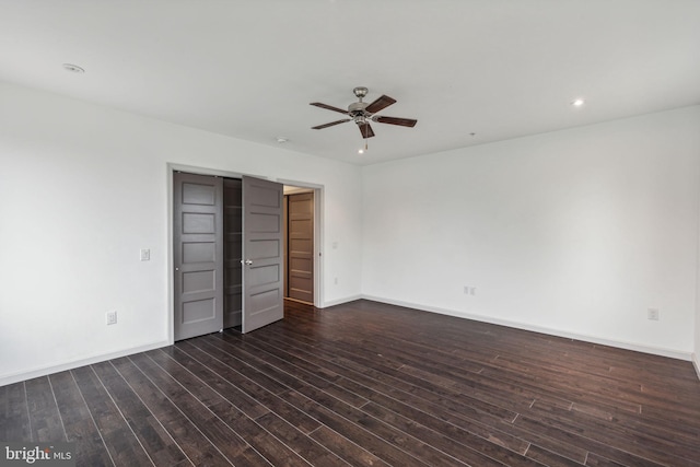 unfurnished bedroom with ceiling fan and dark wood-type flooring