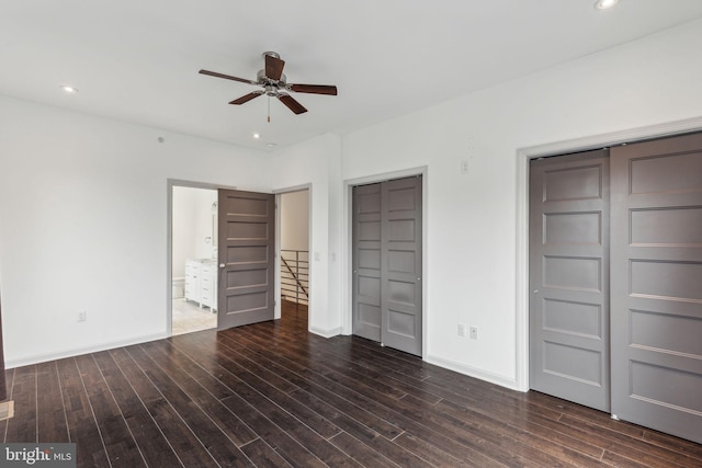 unfurnished bedroom with dark hardwood / wood-style floors, ceiling fan, and connected bathroom