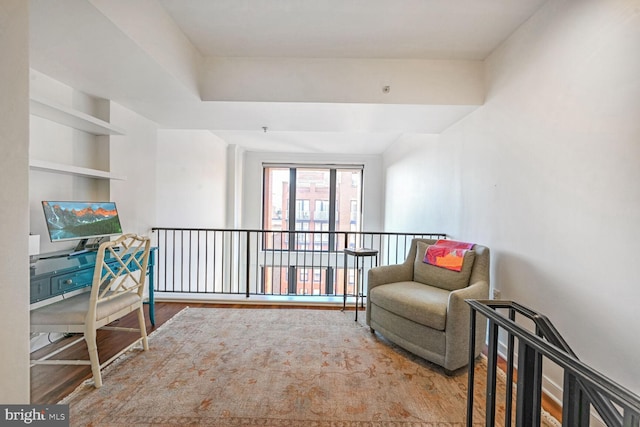 living area with wood-type flooring and built in features