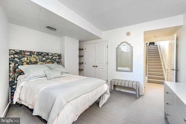 bedroom with light colored carpet and a closet