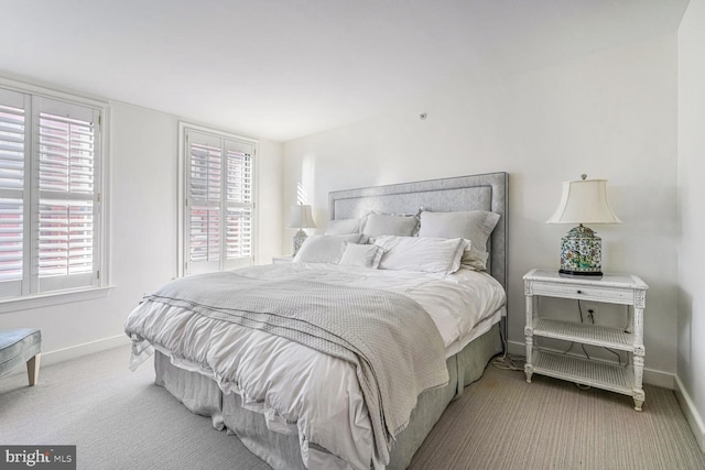 bedroom featuring light carpet and multiple windows