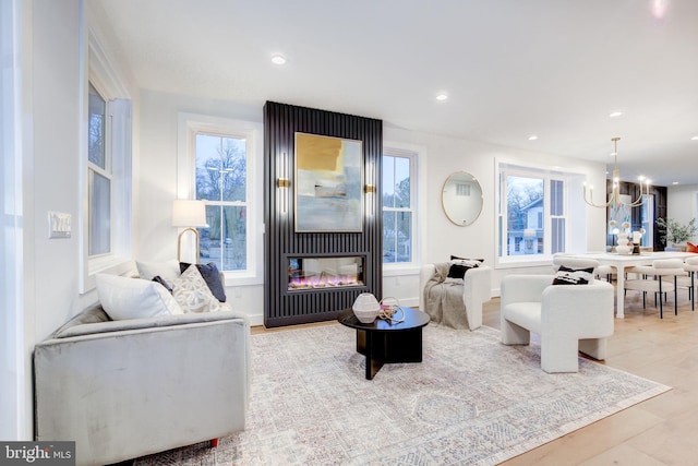 living room with a chandelier and light hardwood / wood-style floors