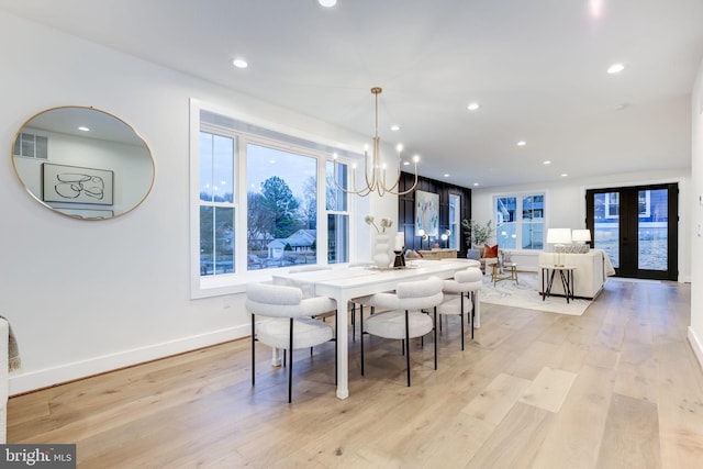 dining room with light hardwood / wood-style floors and a chandelier