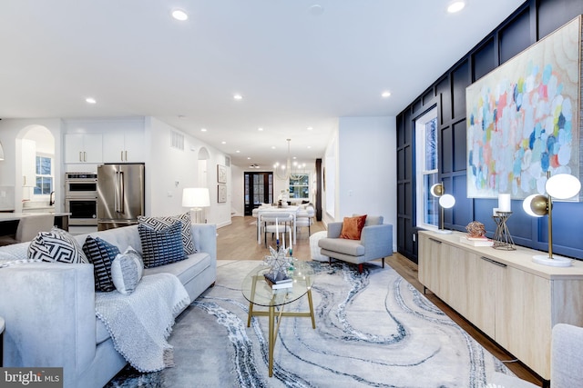 living room featuring an inviting chandelier and light hardwood / wood-style floors