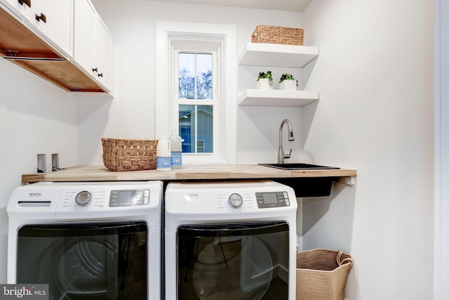 laundry room with cabinets, sink, and washing machine and clothes dryer