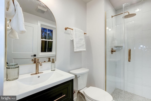 bathroom with vanity, toilet, and a shower with shower door