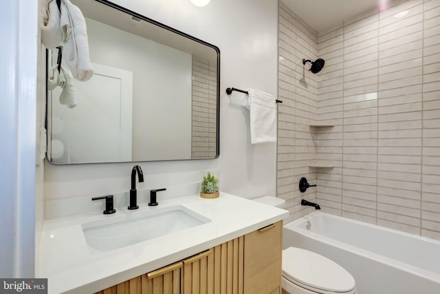 full bathroom with vanity, tiled shower / bath combo, and toilet