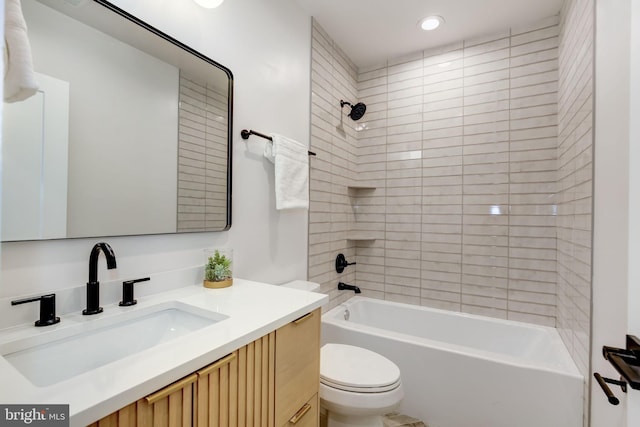 full bathroom with vanity, tiled shower / bath combo, and toilet