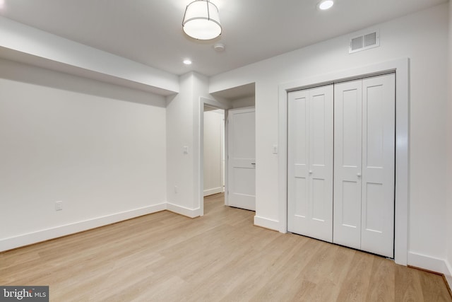 unfurnished bedroom featuring light hardwood / wood-style floors and a closet