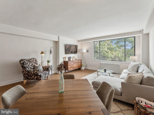 dining area with radiator heating unit and light hardwood / wood-style flooring