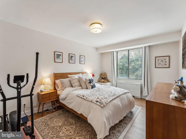 bedroom with hardwood / wood-style floors and radiator