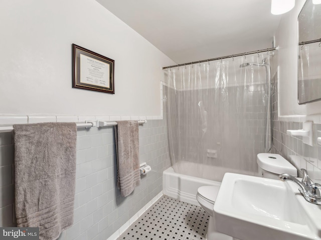 full bathroom with shower / bath combo with shower curtain, sink, tile walls, and toilet