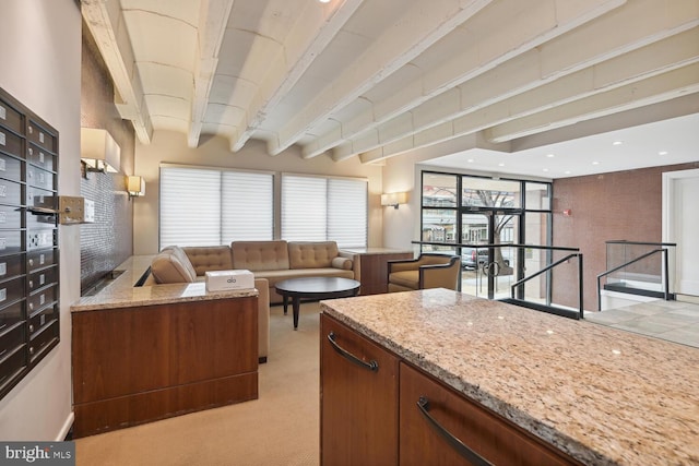 kitchen with beam ceiling, light stone countertops, light carpet, and mail boxes