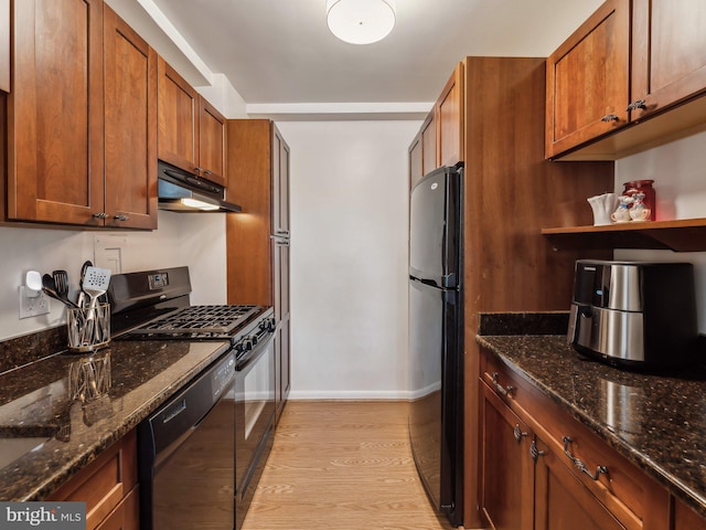 kitchen featuring black appliances, dark stone countertops, and light hardwood / wood-style flooring