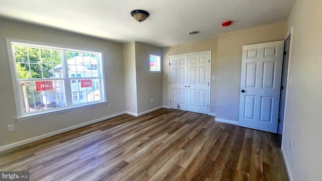 unfurnished bedroom featuring dark hardwood / wood-style floors and a closet