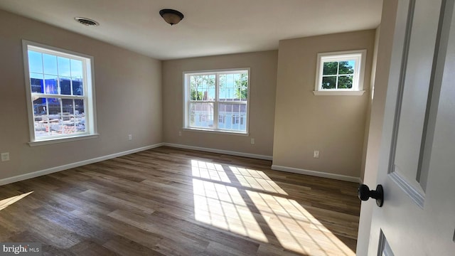 unfurnished room with dark hardwood / wood-style floors and a wealth of natural light