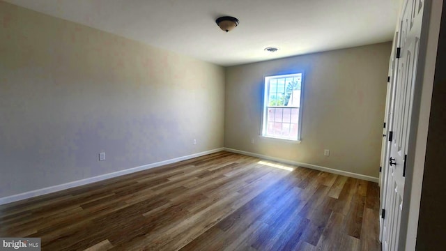 spare room with dark wood-type flooring