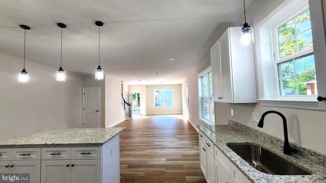 kitchen with white cabinetry, sink, plenty of natural light, and light wood-type flooring