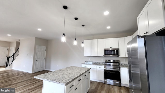 kitchen with white cabinets, stainless steel appliances, and a kitchen island