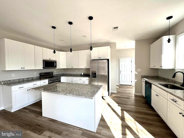 kitchen featuring black appliances, a kitchen island, light stone counters, and white cabinetry