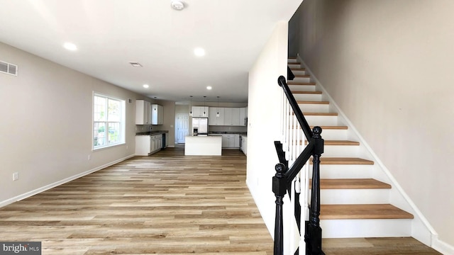 stairway with hardwood / wood-style floors and sink