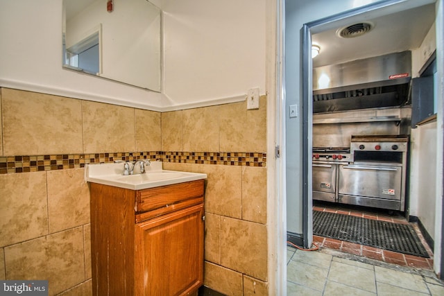 bathroom featuring tile patterned floors, vanity, and tile walls