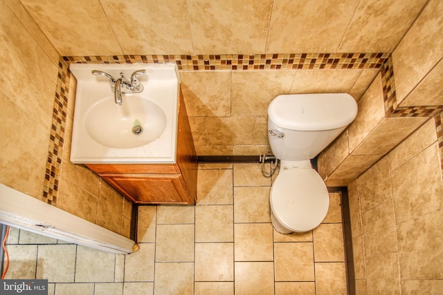 bathroom with vanity, tile walls, and toilet