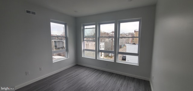 empty room featuring dark hardwood / wood-style floors and a healthy amount of sunlight