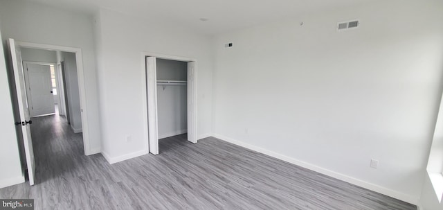 unfurnished bedroom featuring a closet and wood-type flooring