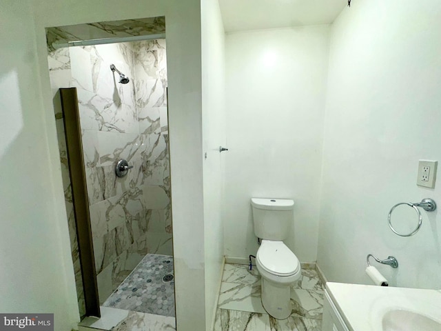 bathroom with vanity, toilet, and a tile shower