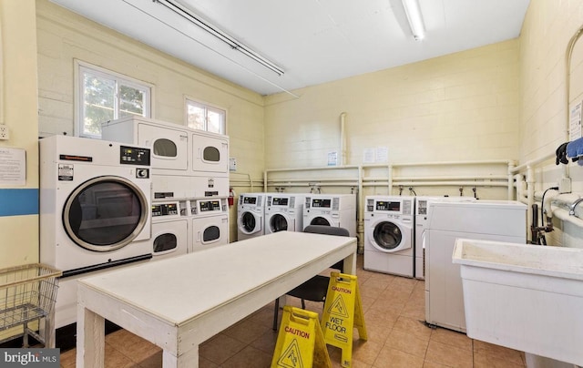 washroom with stacked washing maching and dryer, sink, and washer and dryer