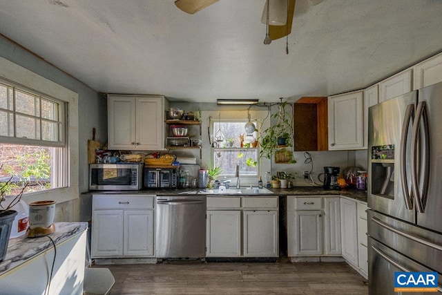 kitchen featuring sink, white cabinetry, stainless steel appliances, and dark wood-type flooring