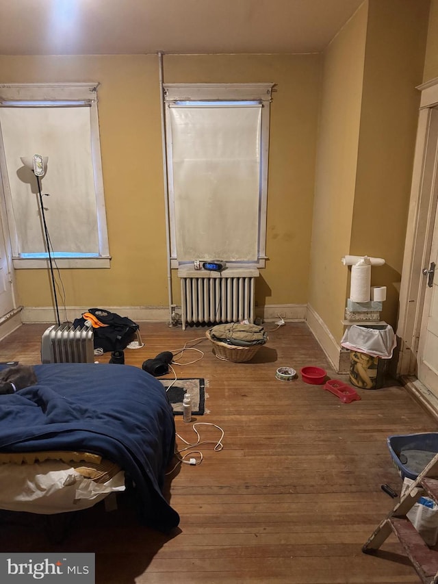 bedroom featuring wood-type flooring and radiator