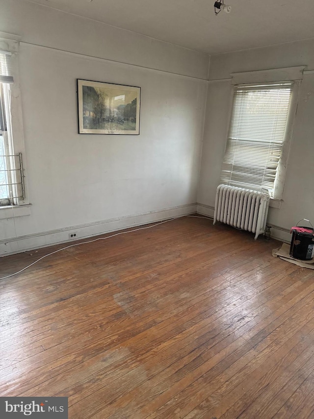 unfurnished room with hardwood / wood-style flooring and radiator