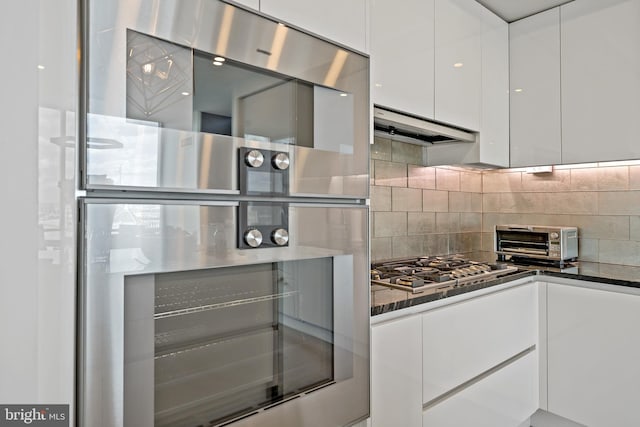 kitchen with backsplash, stainless steel appliances, and white cabinetry