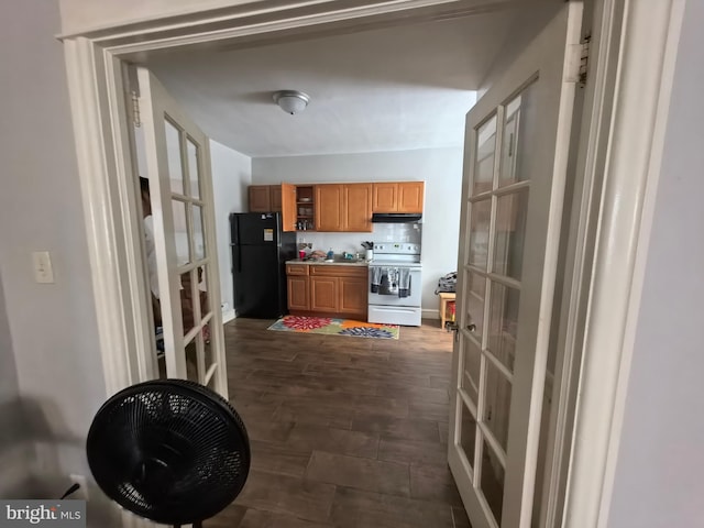 kitchen featuring white range with electric stovetop, black fridge, french doors, and dark hardwood / wood-style floors