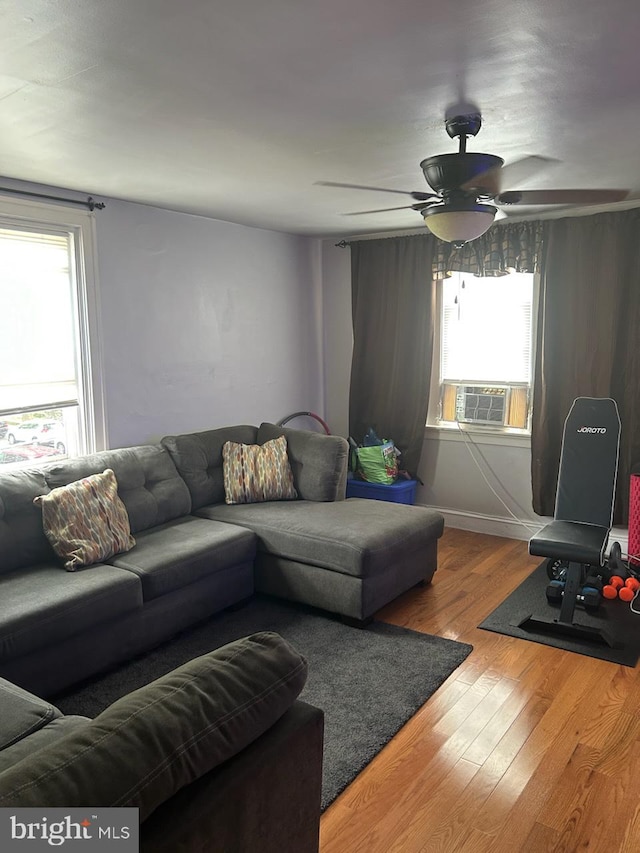 living room with ceiling fan, cooling unit, and hardwood / wood-style flooring