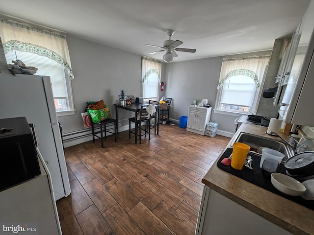 kitchen featuring dark hardwood / wood-style floors, ceiling fan, and baseboard heating