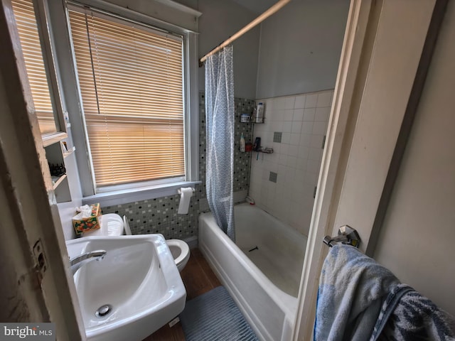 full bathroom featuring toilet, shower / bathtub combination with curtain, and sink