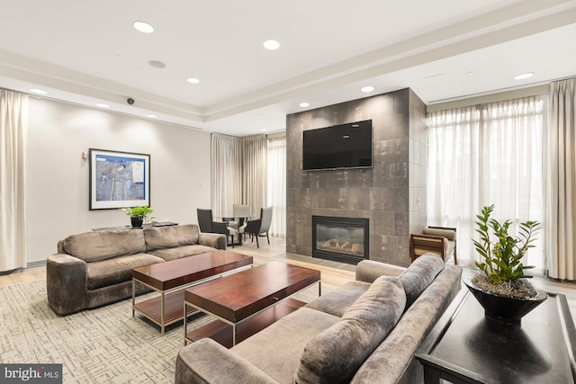 living room featuring a tile fireplace and light hardwood / wood-style floors