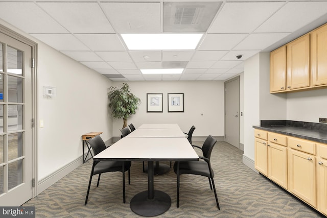 carpeted dining room with a drop ceiling