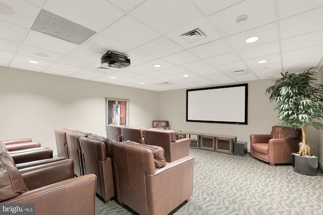 cinema room with a paneled ceiling and carpet