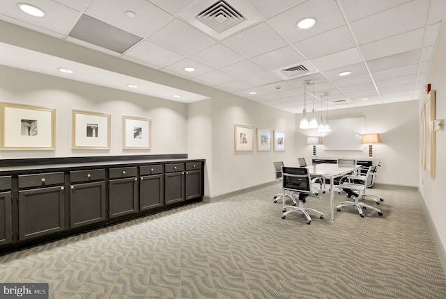 carpeted office with a paneled ceiling