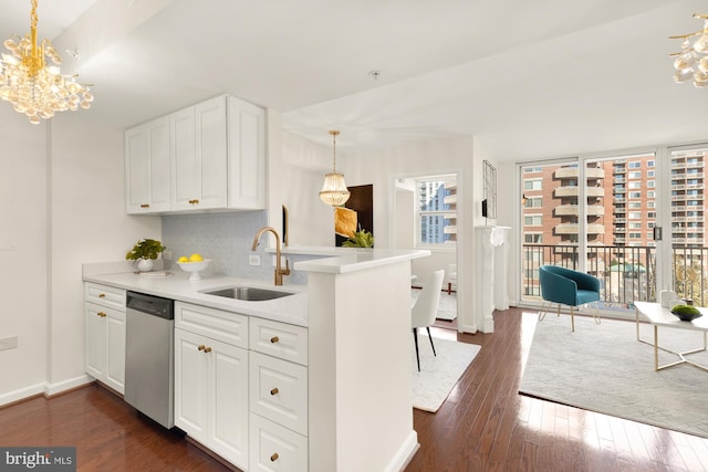 kitchen featuring white cabinetry, dishwasher, sink, and kitchen peninsula