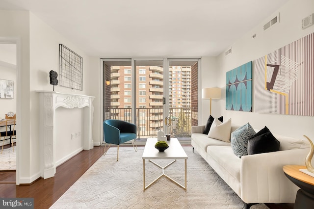 living room with dark hardwood / wood-style floors and floor to ceiling windows