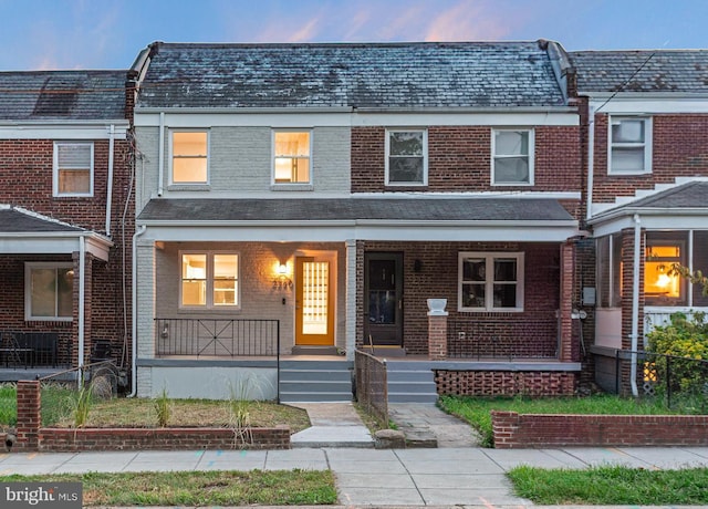 townhome / multi-family property featuring covered porch